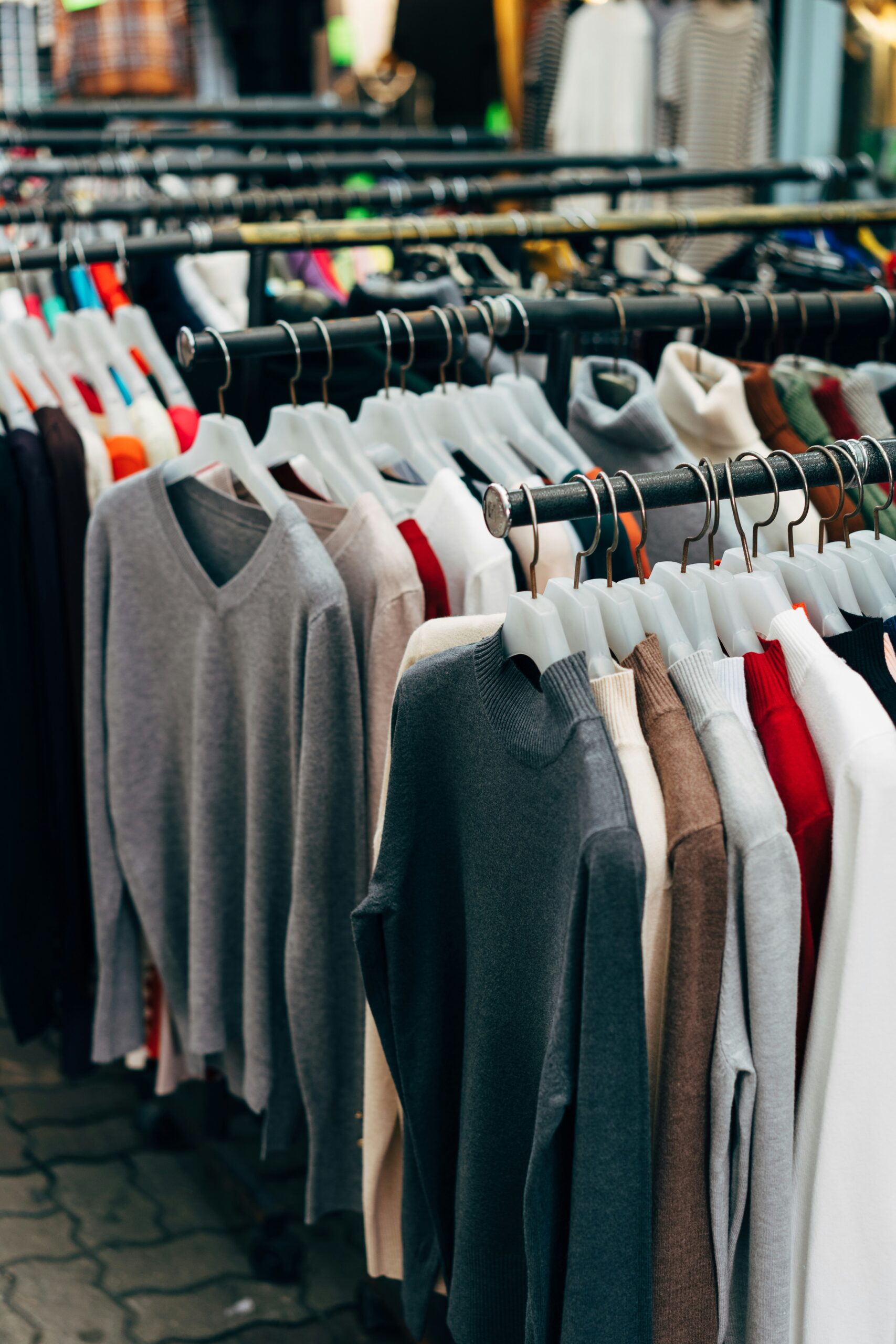 assortment of clothes hanging on racks in the best Portland thrift stores