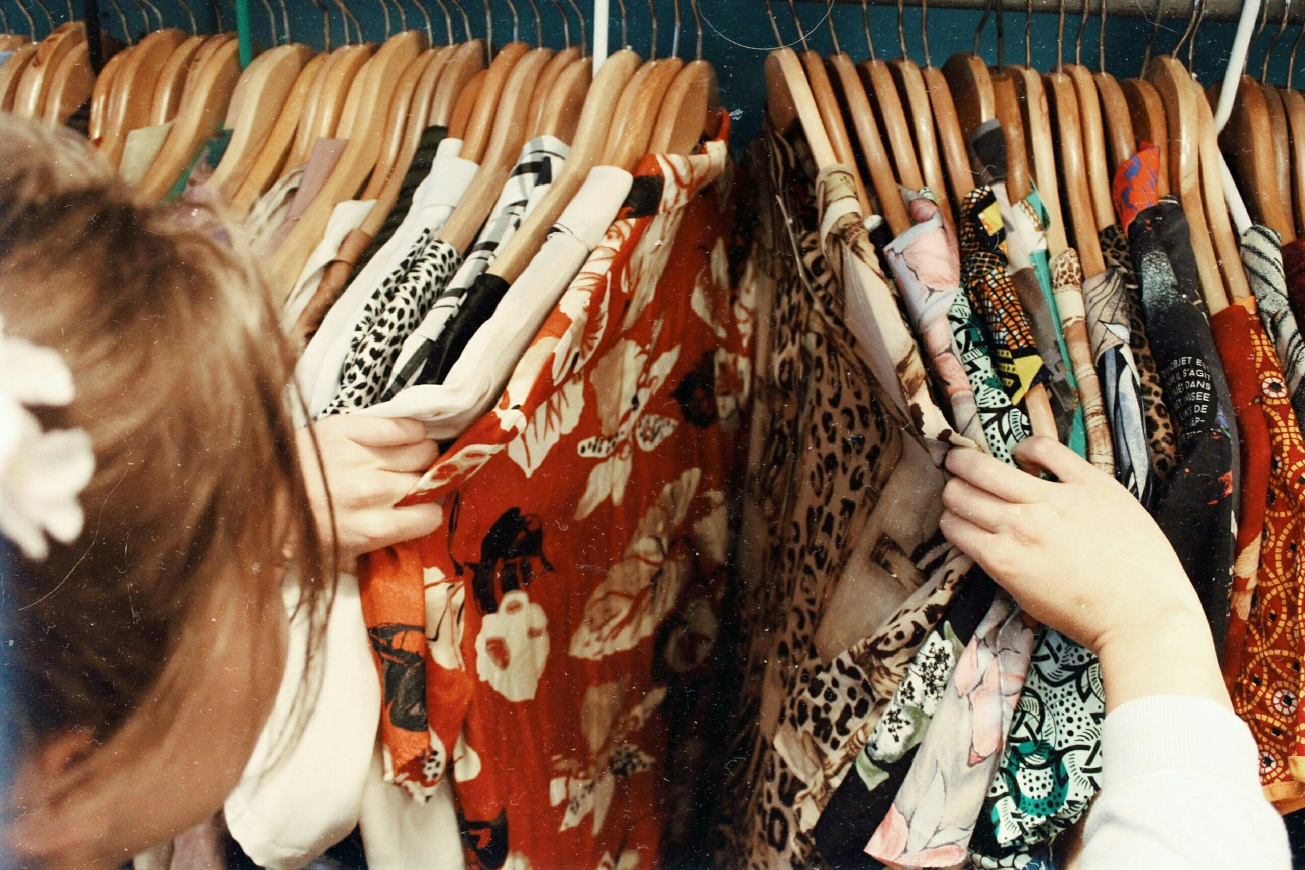 individual browsing through clothing items while shopping