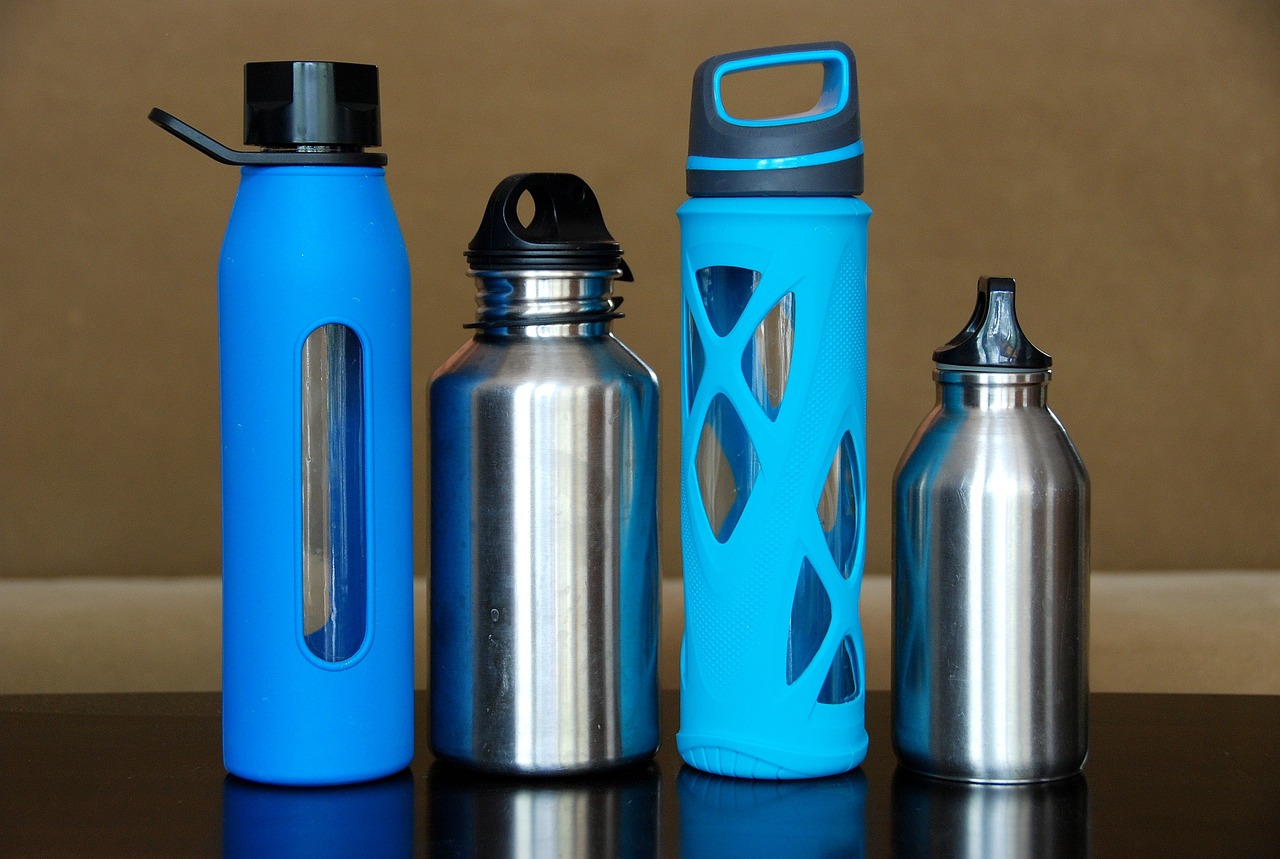 four reusable water bottles sitting next to each other on counter