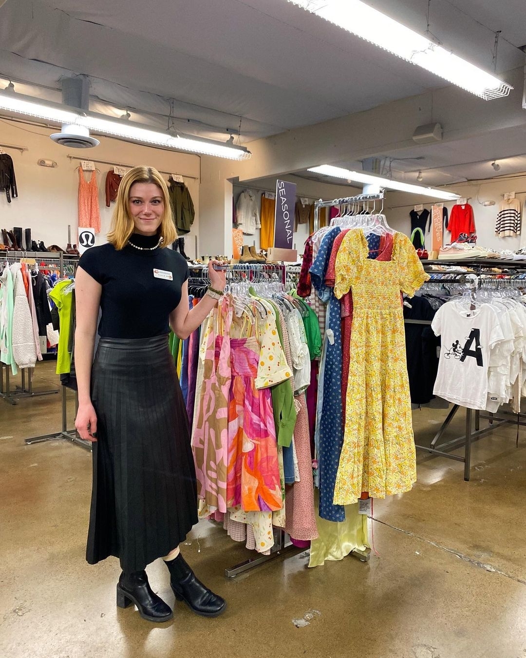 female standing next to clothing rack in thrift store; embracing best thrift stores in San Francisco