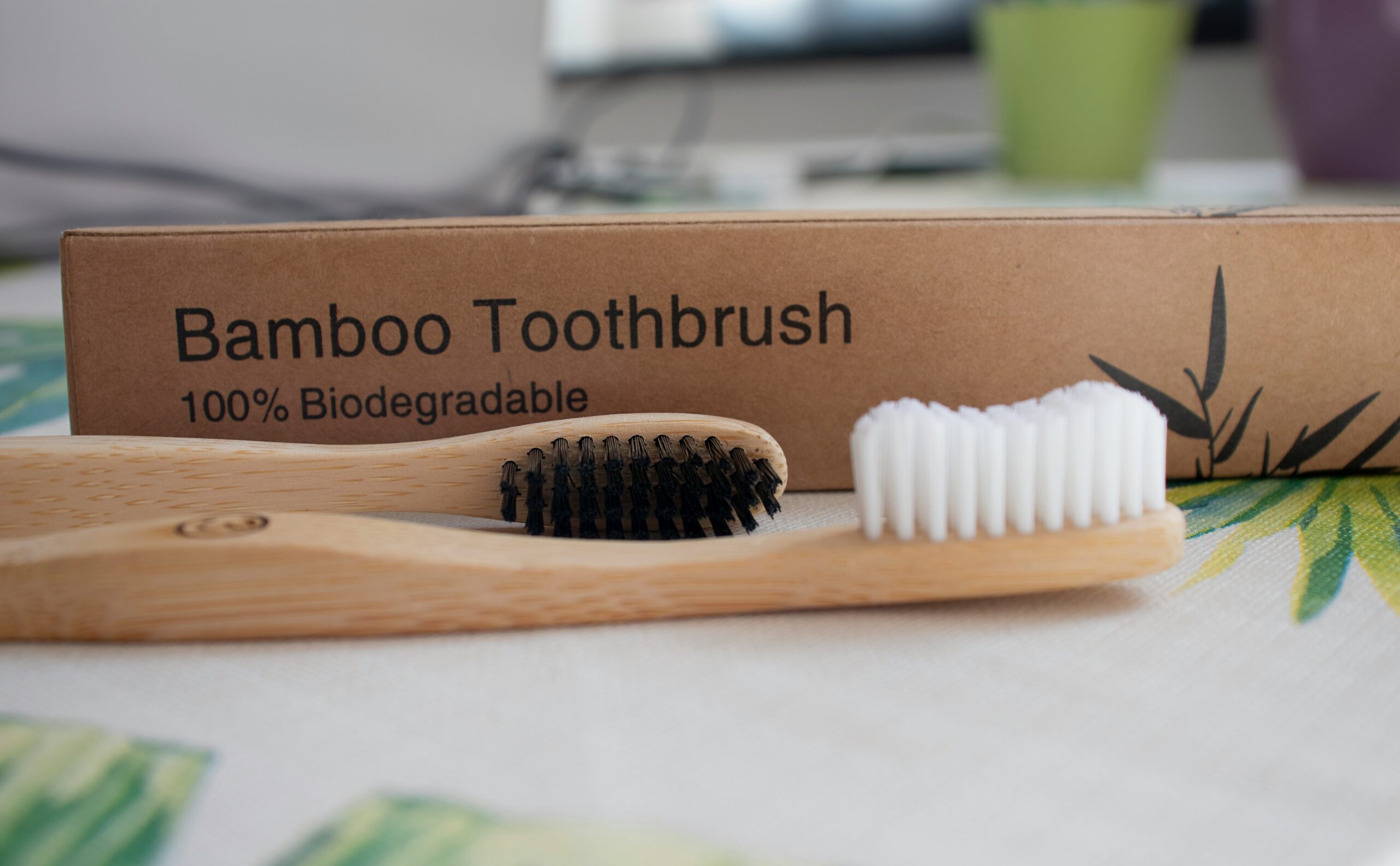 bamboo toothbrush sitting in front of packing. Embracing best zero waste toothpaste brands