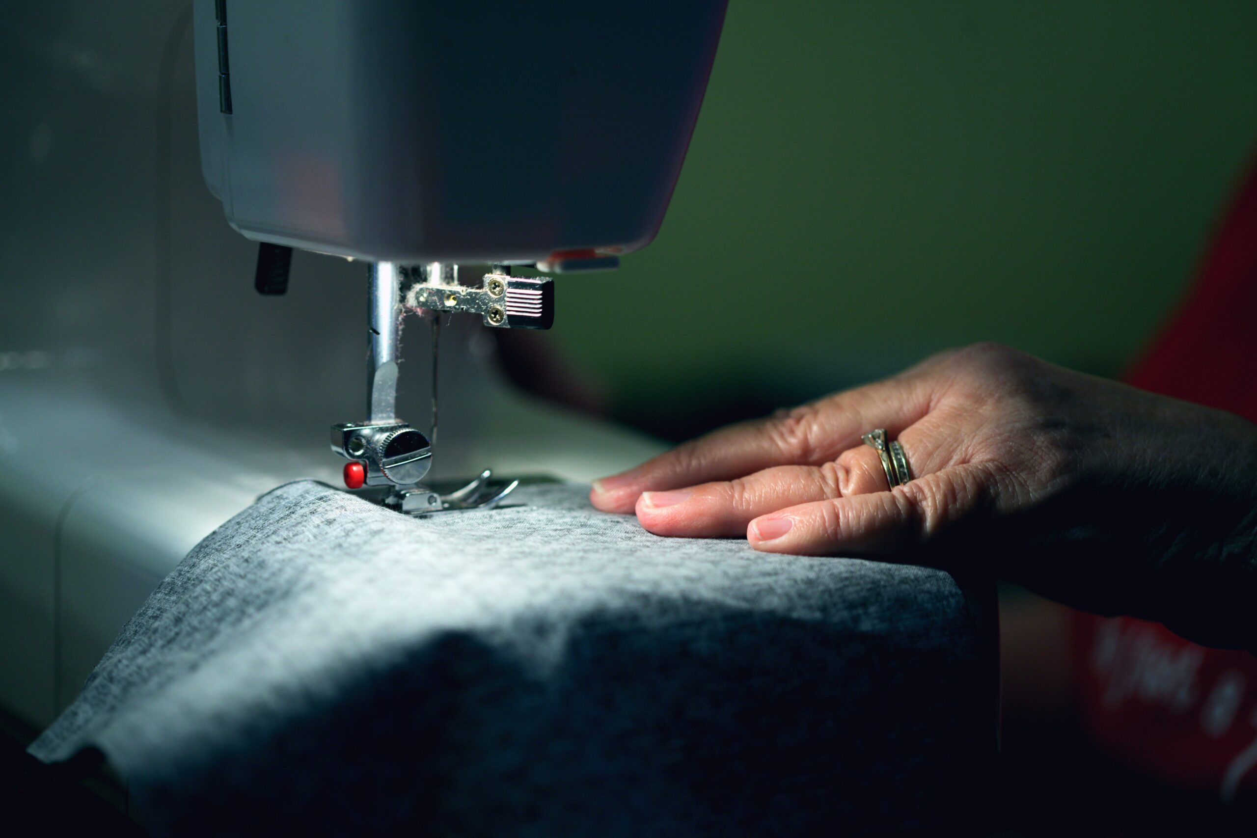 An individual sewing viscose fabric on a sewing machine.