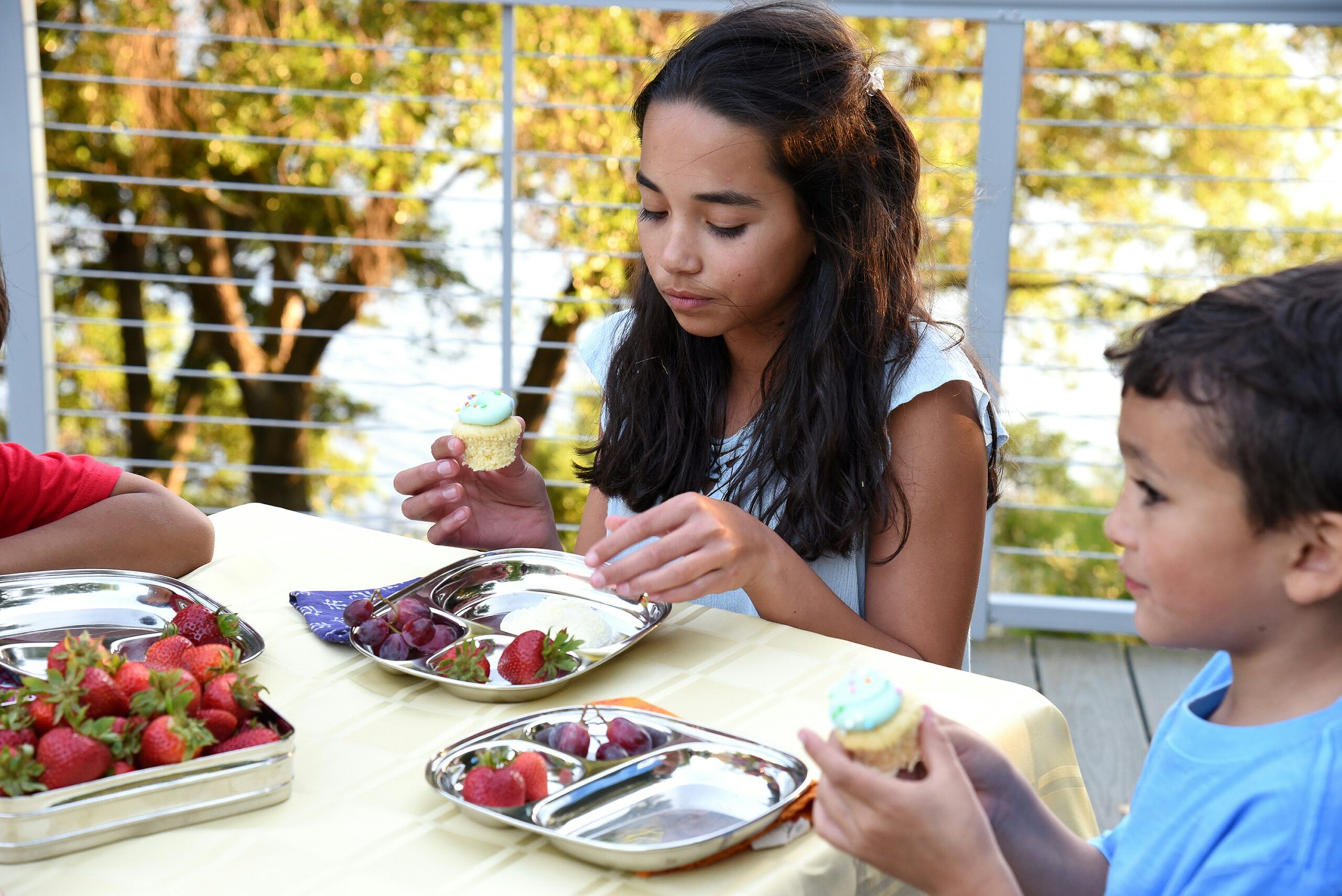 Kids sitting around a table eating a zero waste lunch with sustainable plates, embracing zero waste lunch ideas