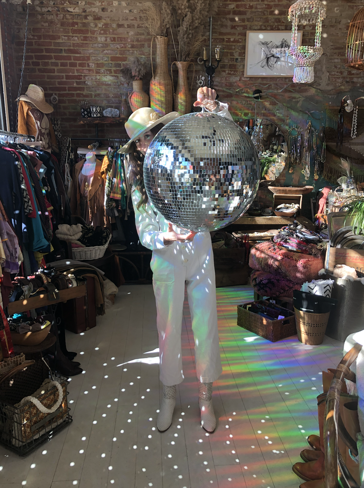 photo of thrift store in Detroit with someone holding a disco ball