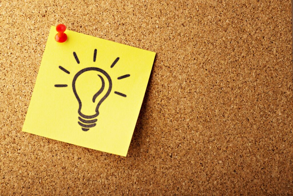 a sticky note with a light bulb drawn on it, signifying an idea