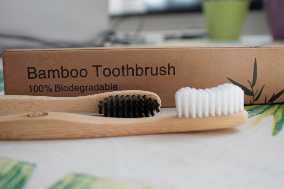 bamboo toothbrush sitting in front of packing. Embracing best zero waste toothpaste brands