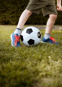 kid wearing pre-loved sports shoes while playing soccer