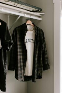 flannel shirt over vintage t-shirt handing from hanger in closet