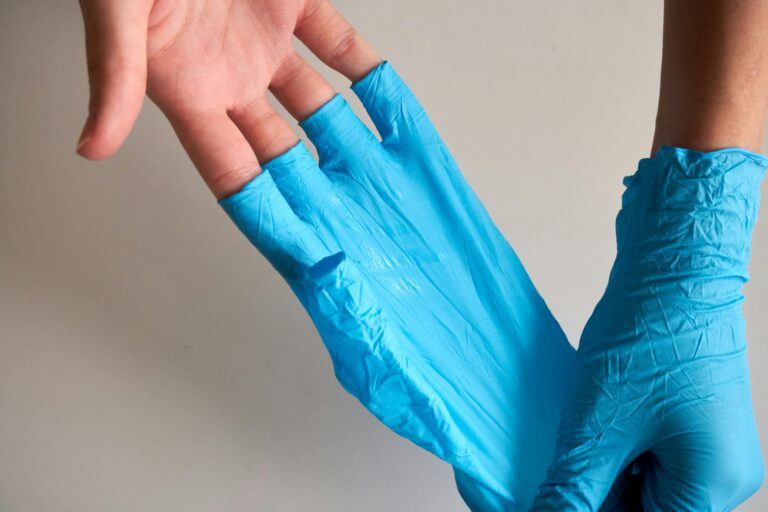 Person taking latex gloves off their hands.